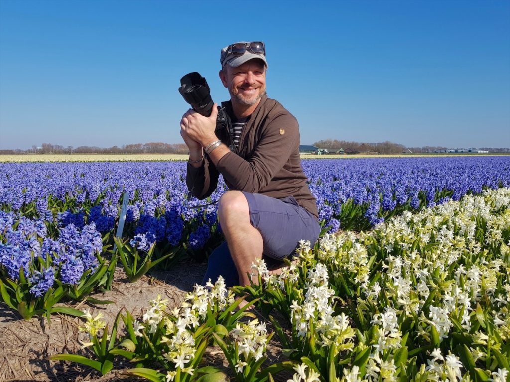 Man in field of hyacinths. Tom van der Leij photography