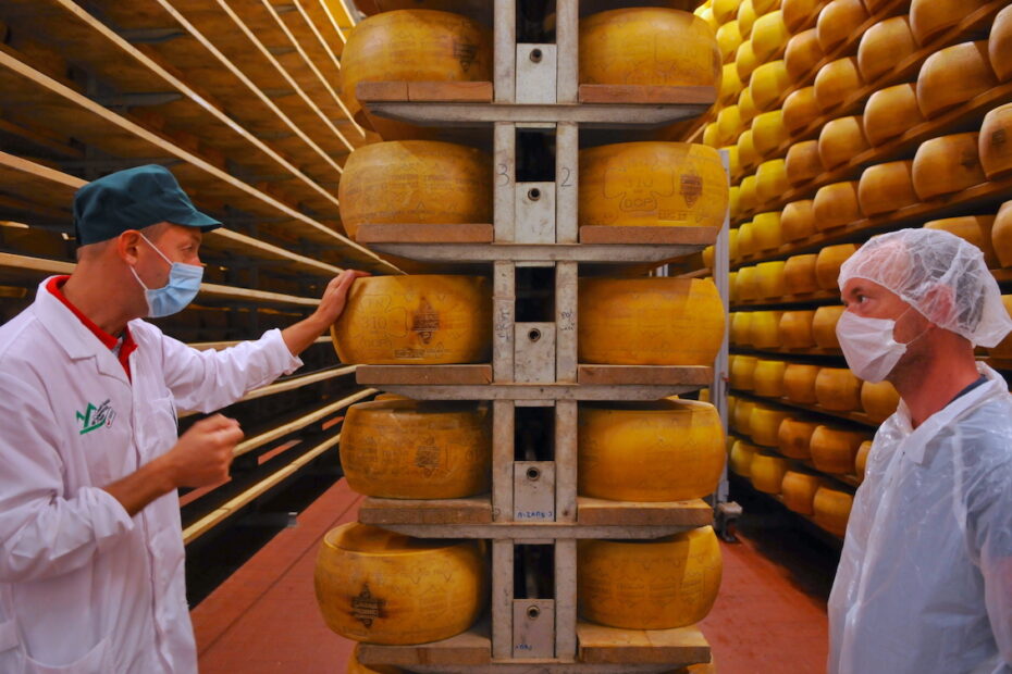 Men in cheese storage facility in Italy by Amsterdam photographer Tom van der Leij