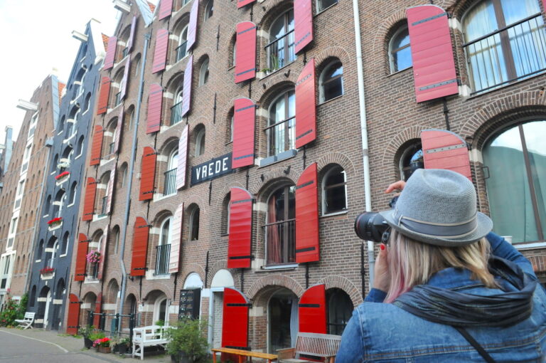 Woman taking a photo on Prinseneiland in Amsterdam. Photo by Tom van der Leij