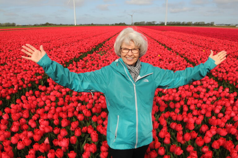 Woman in Dutch red tulip fields by Amsterdam photographer Tom van der Leij