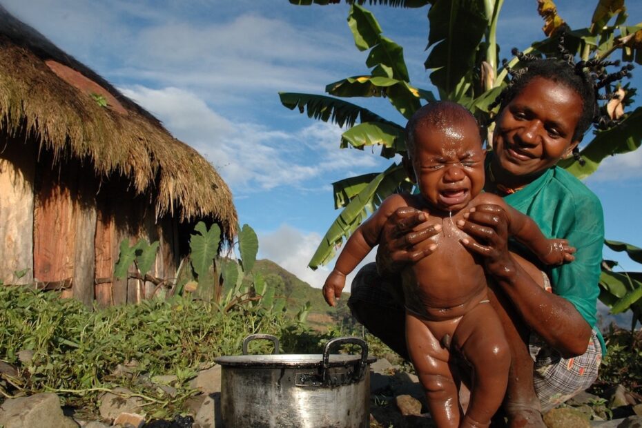 Baby being washed by mother in Papua New Guinea